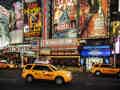 Lebhafte nächtliche Straßenszene in New York mit Hoteleingang, Theatermarkise, Wechselstube und vorbeifahrenden gelben Taxis.