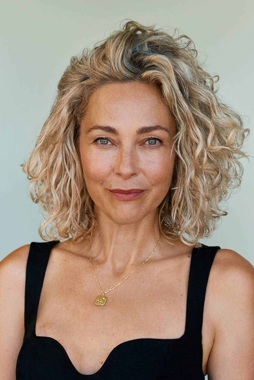 smiling woman with dyed blonde curls