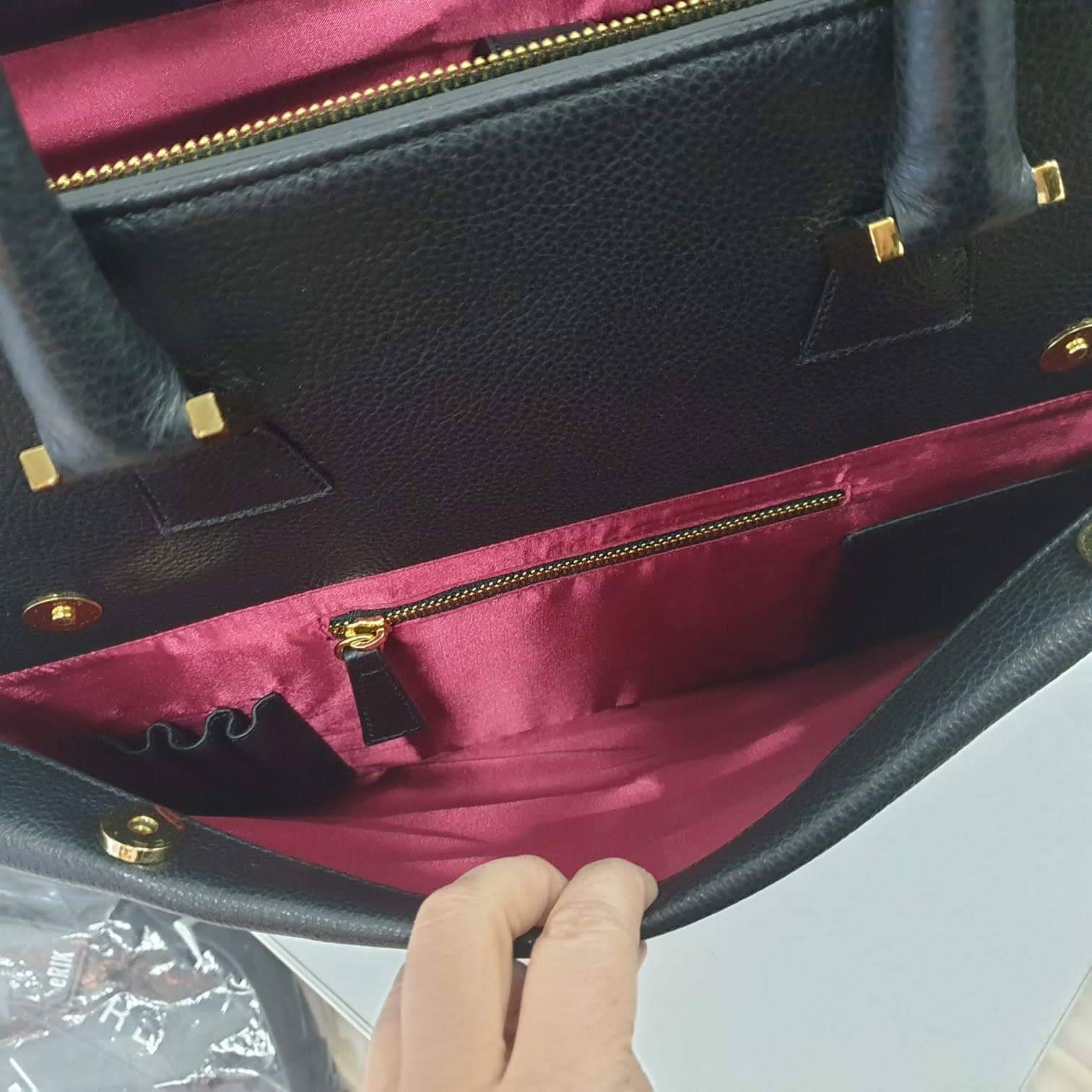 inside of a large black leather laptop bag in a bright shiny fabric