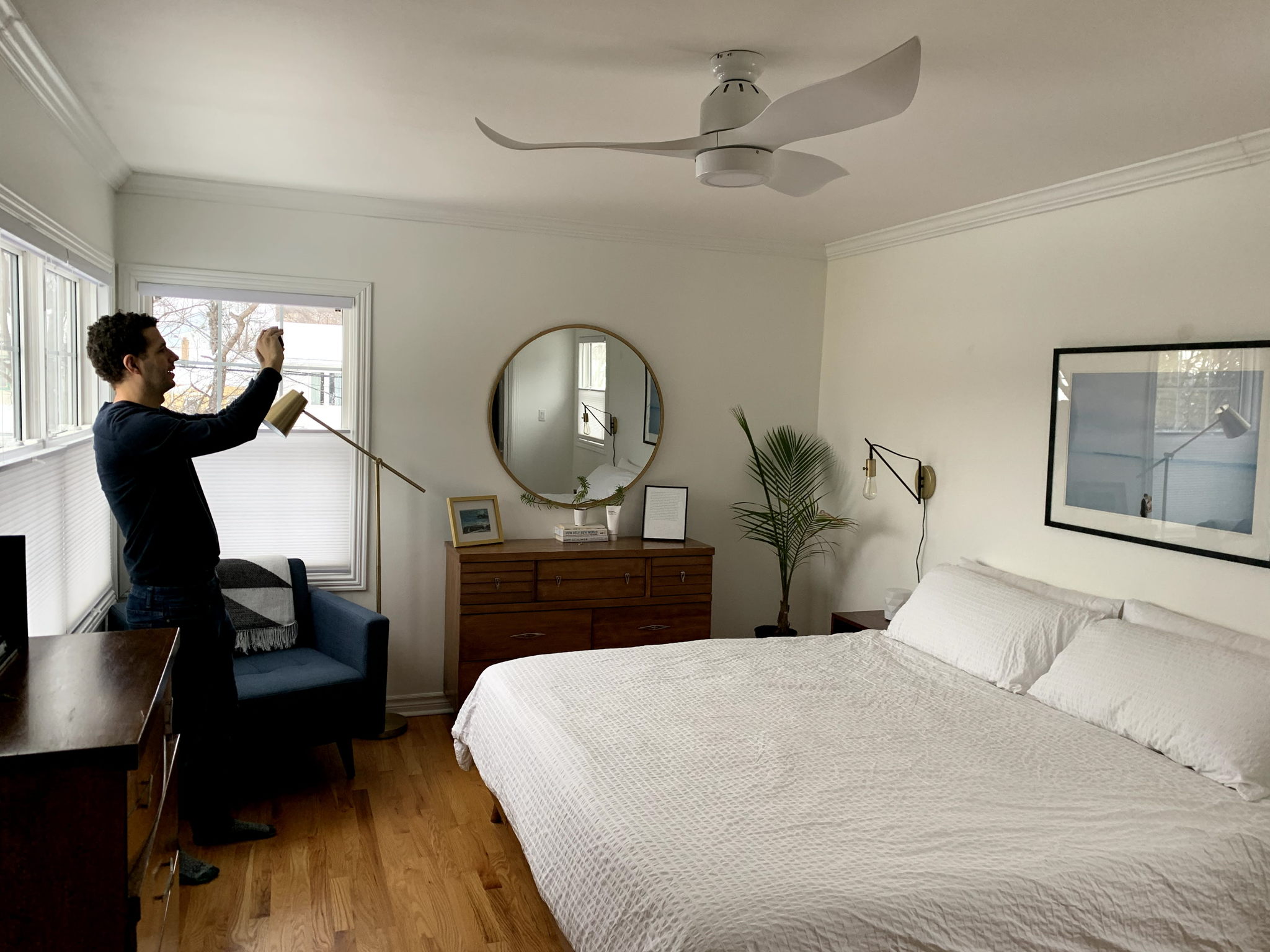 man holding phone in master bedroom