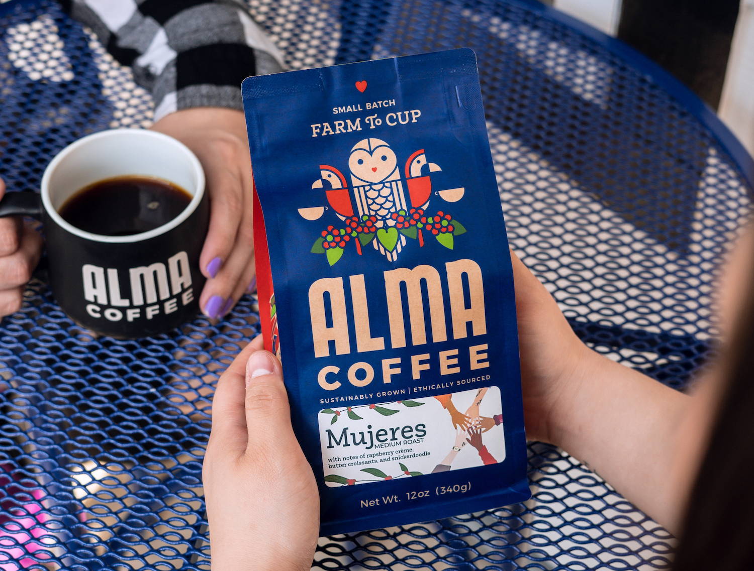 Bag of Alma Coffee's Mujeres Roast in a flower patch