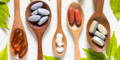 five wooden spoons, each containing different essential vitamin tablets