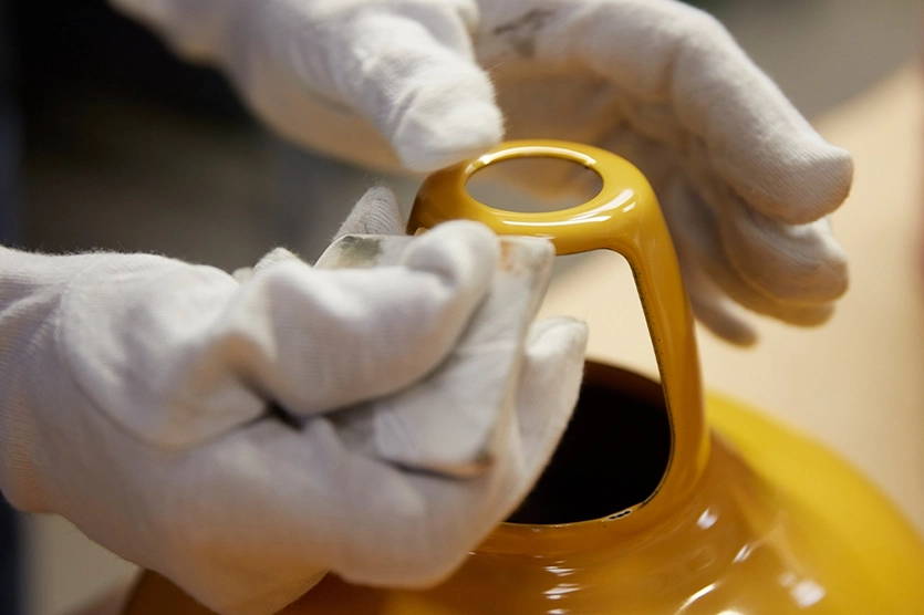 Two hands sanding the sharp edges of a Deep Yellow Coolicon shade