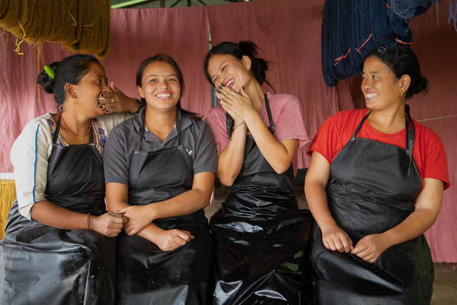 Four women sitting and laughing from Kakani Artisan Cooperative.
