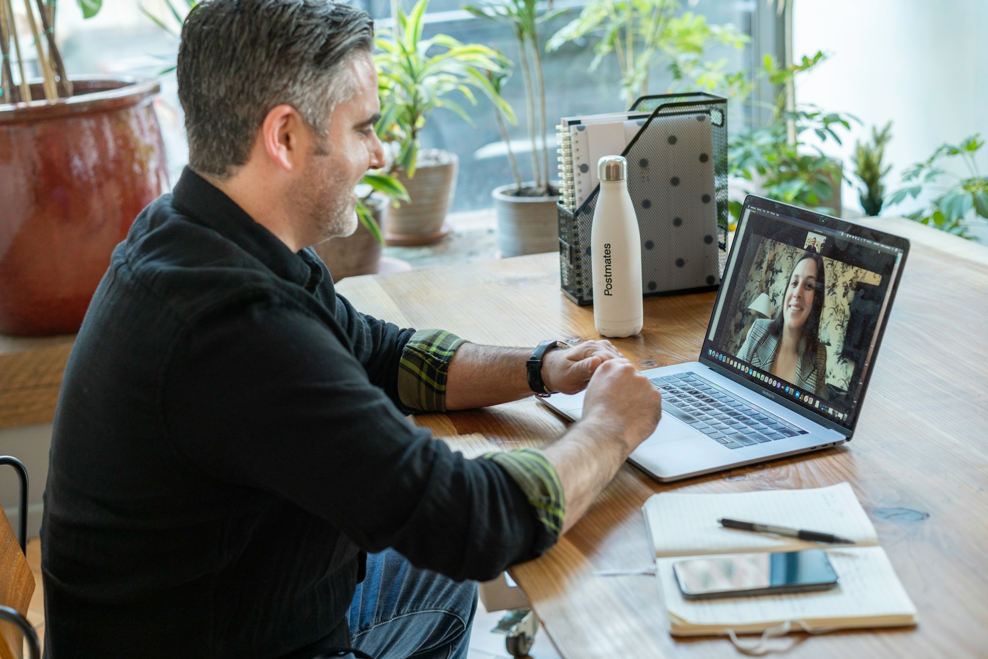A business owner sits on a video call with a potential client on a laptop