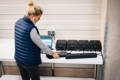 Une femme teste des batteries de vélo électriques dans un atelier avec un ordinateur connecté