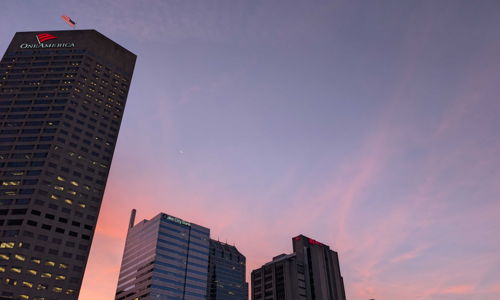 Cityscape at twilight with tall buildings, colorful sunset sky, evoking calmness, hope, and appreciation for urban beauty.