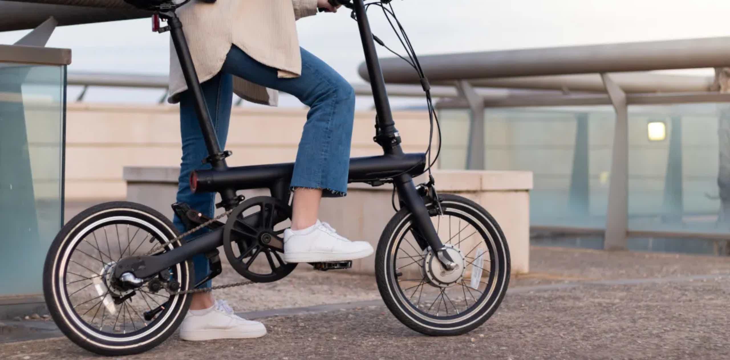 Imagen de recurso de una persona parada con una e-bike plegable.