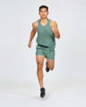 Man wearing patterned running vest and shorts in a turquoise green, from sustainable clothing brand Janji specialising in sustainable running clothing.