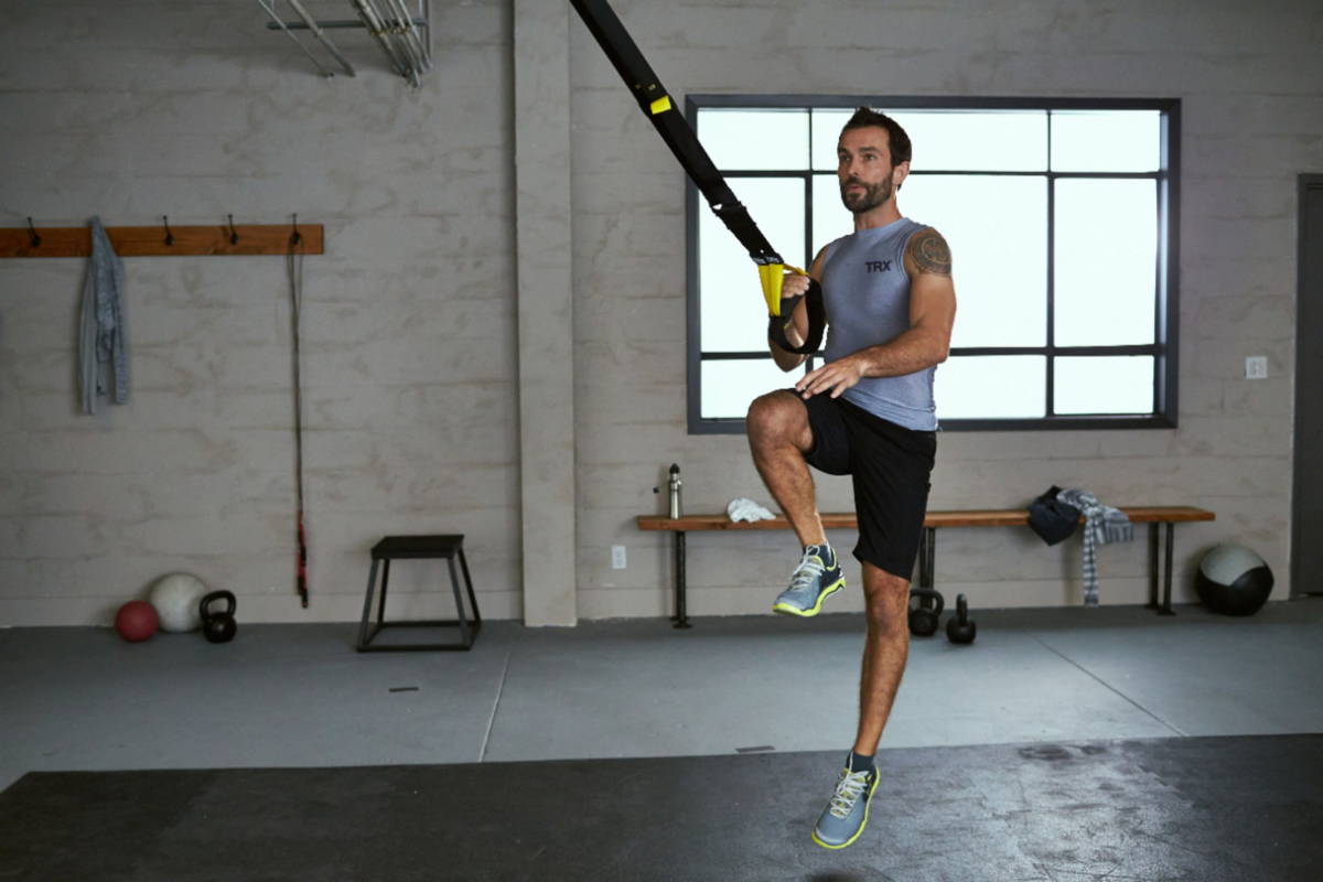 athlete exercising with suspension trainer at gym