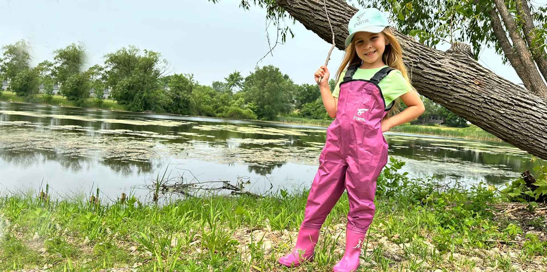 This kid wears the waterproof fishing chest waders in pink color