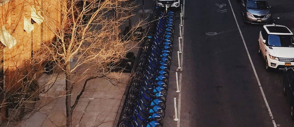 a row of citi bike electric bikes at a docking station on a street in NYC