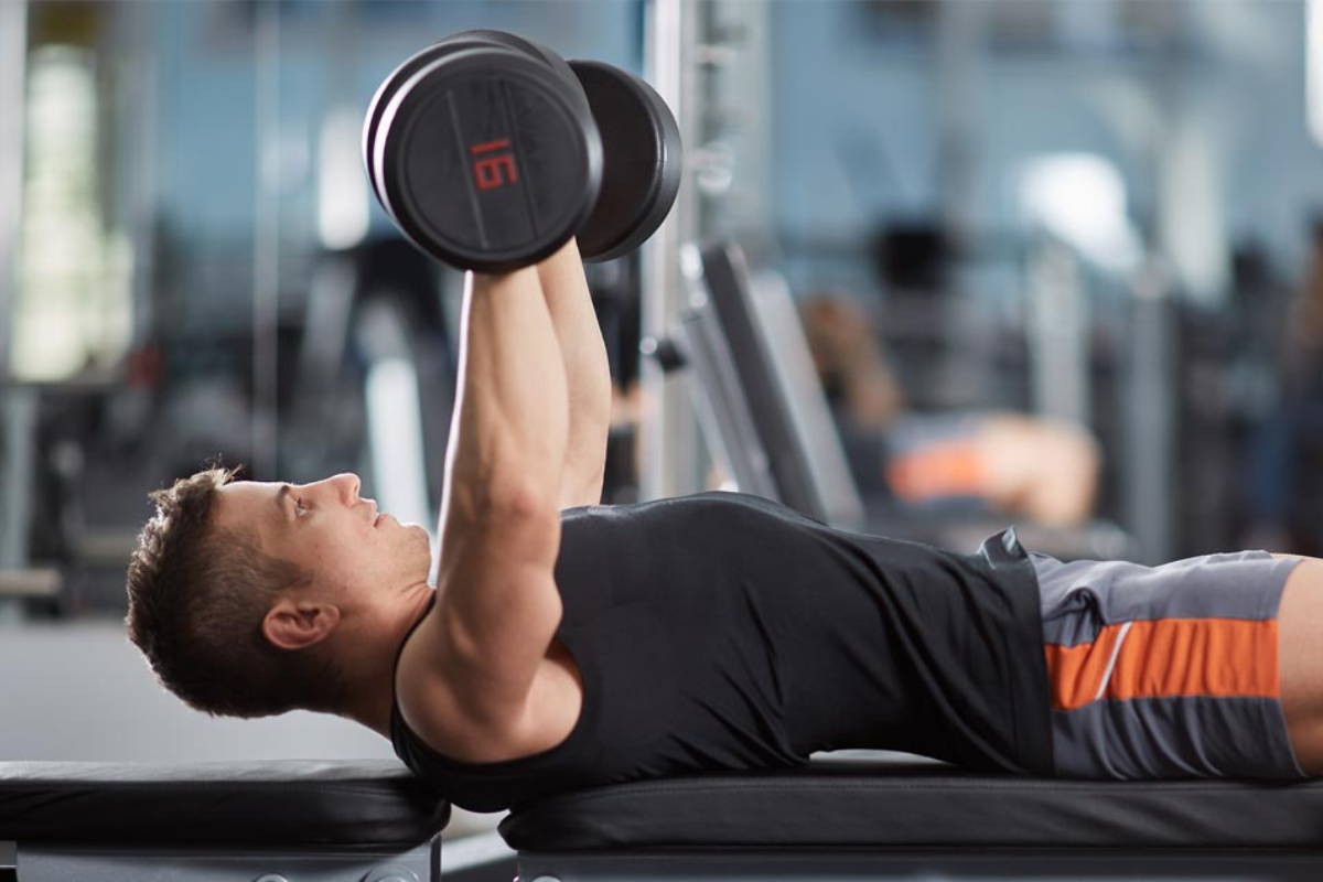 athlete exercising on a weight bench at gym