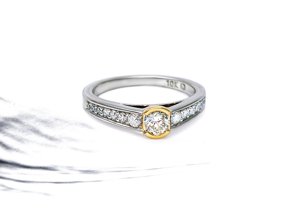 White gold semi eternity with yellow gold and diamond center.