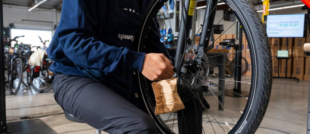 Upway mechanic fixing electric bike wheel in stand