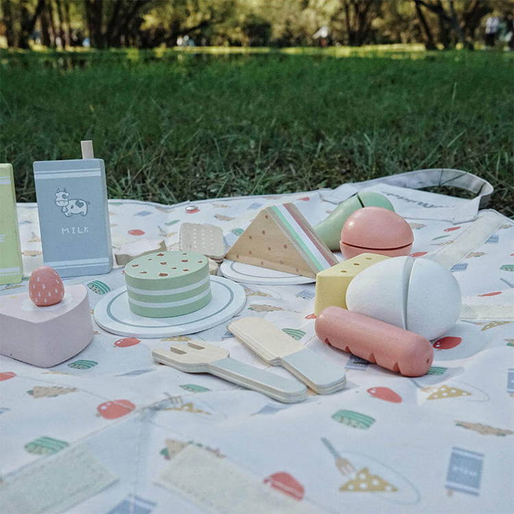Cute pretend-play Montessori Picnic Set placed on the grass.