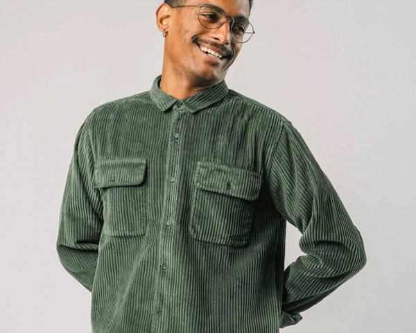 Man wearing green organic cotton cord overshirt sold on the men's sustainable clothing brand marketplace, Brothers We Stand, based in the UK