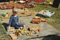 Girl playing with wooden toys outside on a sunny day.