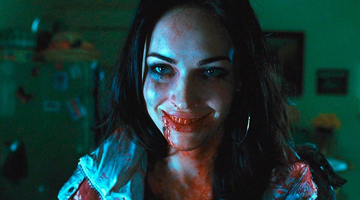 Jennifer close to the camera with a devilish smile covered in blood.