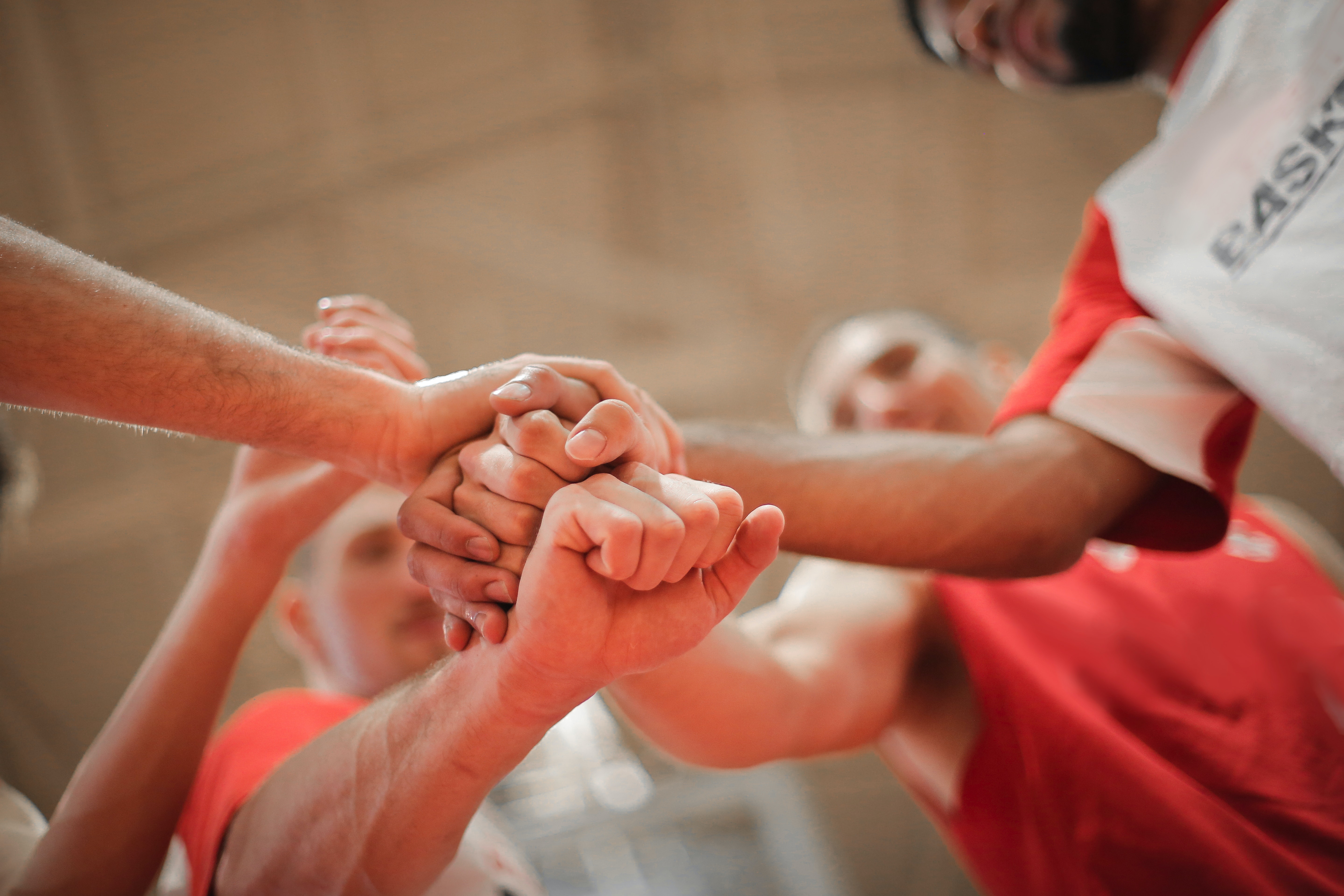 A close up of a team getting ready to play as they put their hands in the center before starting.  A close up of a team getting ready to play as they put their hands in the center before starting.