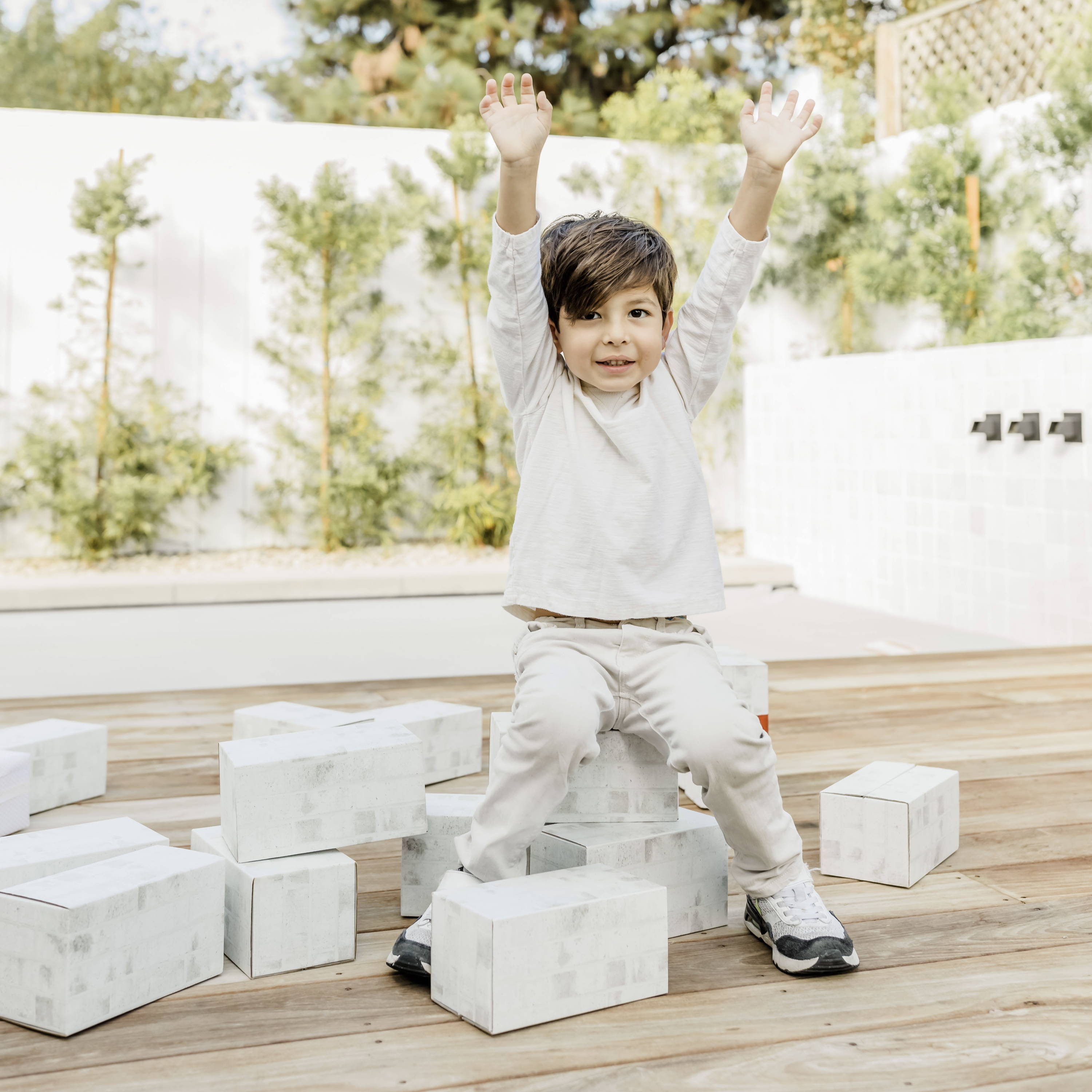 toddler sitting on white building blocks