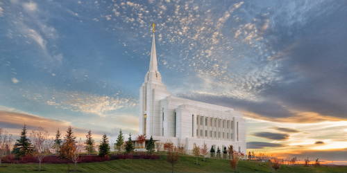 Panoramic Rexburg temple picture against a blue and orange sky.