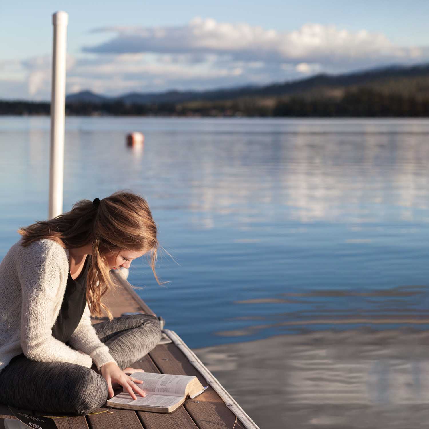 woman reading on lake