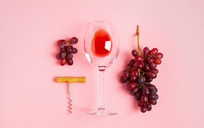 Grapes, a wine glass, and a wine opener for Confetti's Virtual Wine Tasting Team Building