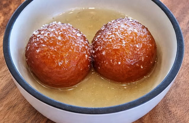 Gulab Jamun — two golden dumplings soaked in warm syrup