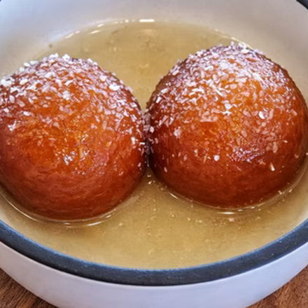 Gulab Jamun — two golden dumplings soaked in syrup
