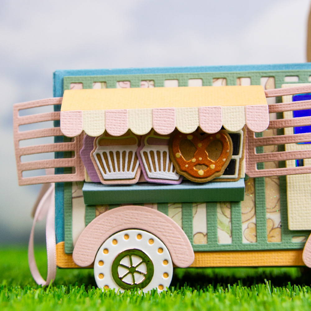 Close up image of a paper crafted sweet treat van displaying pretzels and cupcakes