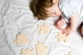 Baby napping next to puzzles. 