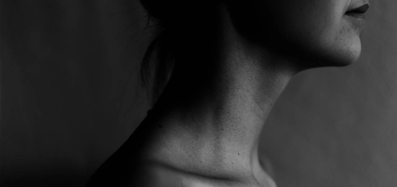 Schwarzweiß Fotografie der Schulter- und Halspartie einer Frau im Profil