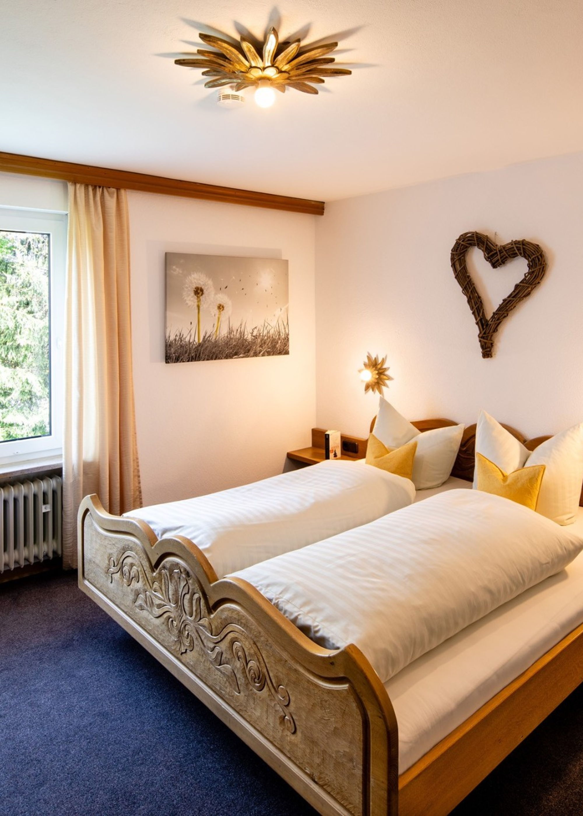 Gemütliches Schlafzimmer mit Holzmöbeln in einer KönigsCard Ferienwohnung in Pfronten, Allgäu