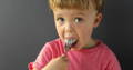 Baby putting a decoration on a birthday cake.