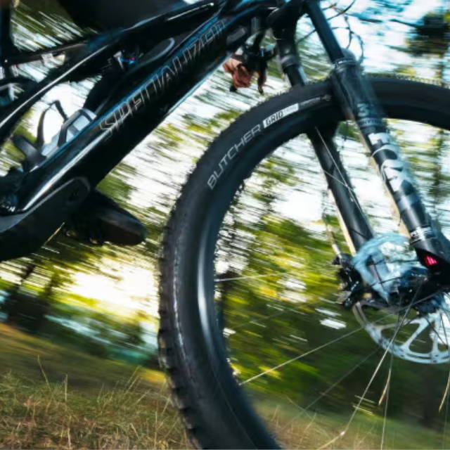 a a person riding an electric mountain bike down a hill in the forest
