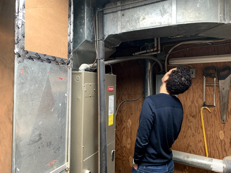 man looking up and inspecting ductwork