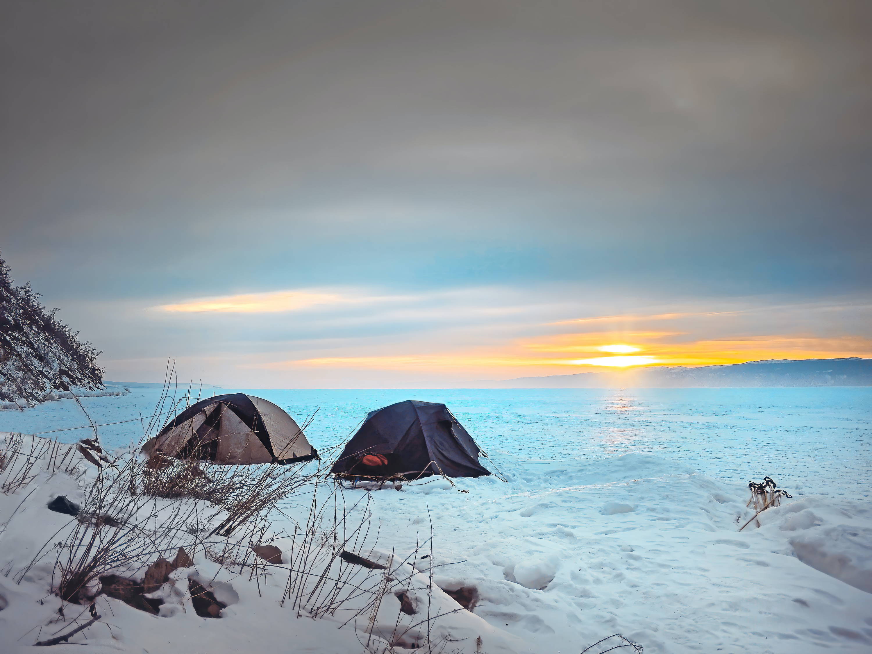 Randonner avec des raquettes en hiver et planter sa tente Mount Trail au coucher du soleil.