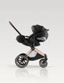 Black CYBEX Cloud T car seat on the Rosegold frame of the stroller, in front of a White Studio Background.