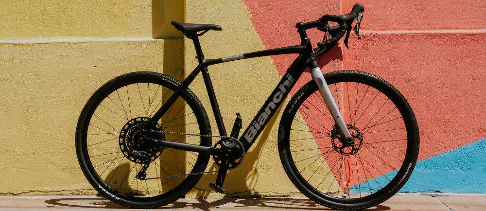 Bianchi E-Impulso electric gravel bike in front of painted wall
