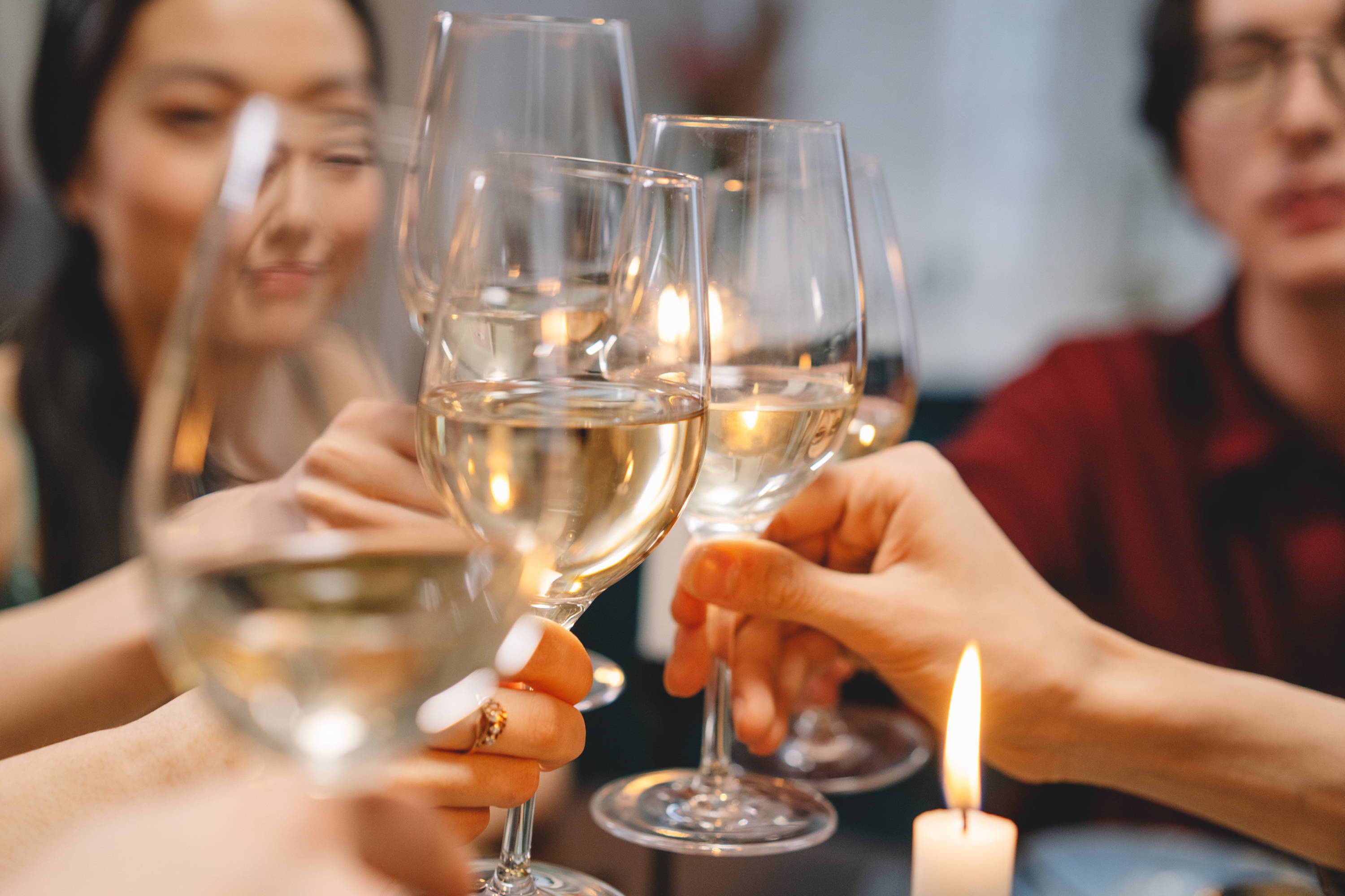 Table toasting with full glasses of mineral wine.