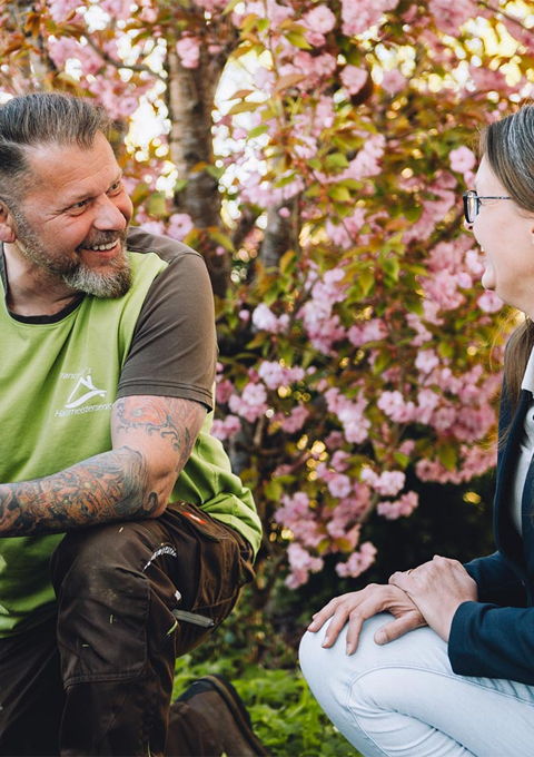 Mitarbeiter von Francesco's Hausmeisterservice Kempten im Allgäu bei der Gartenpflege im Gespräch mit einer Kundin