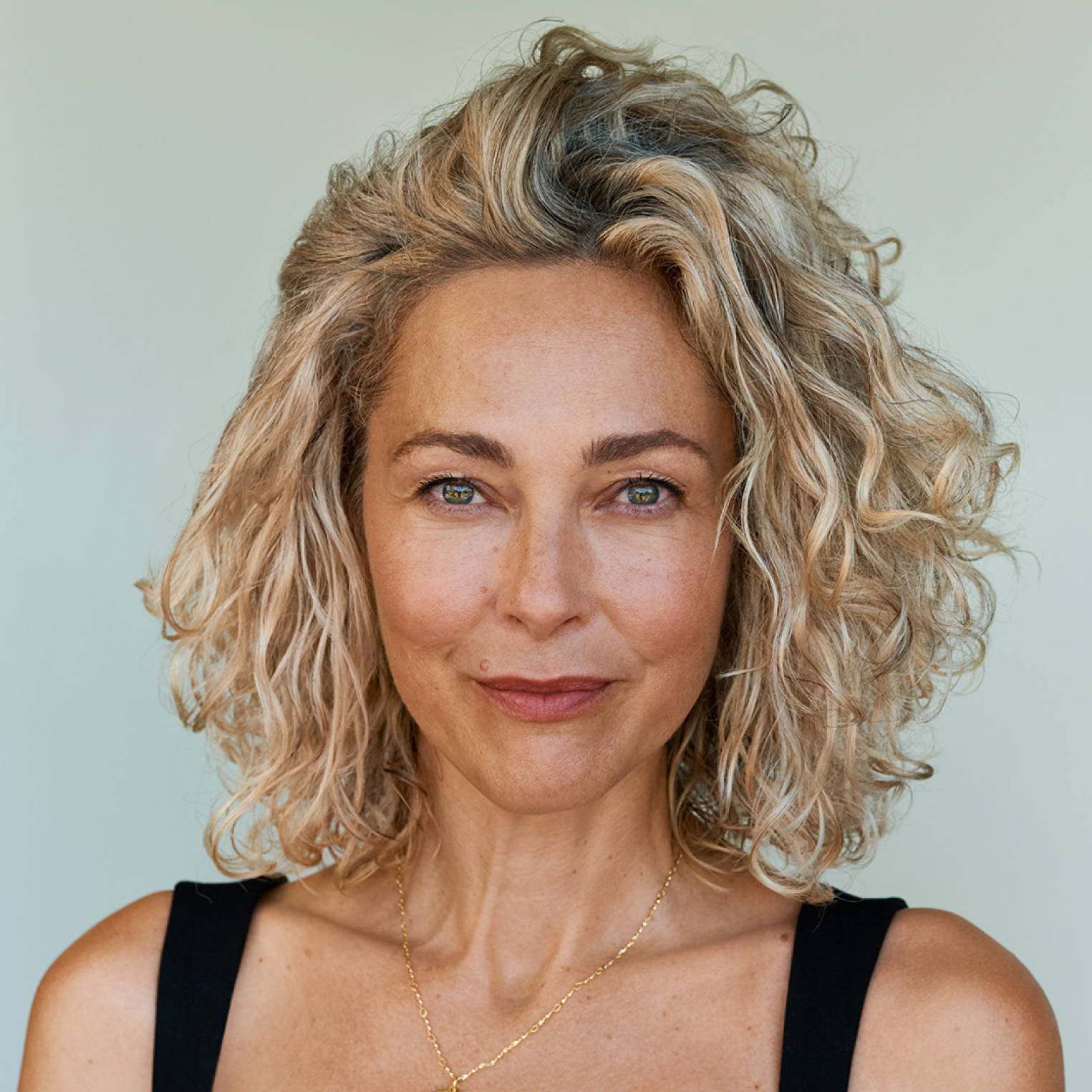 smiling woman with dyed blonde curls