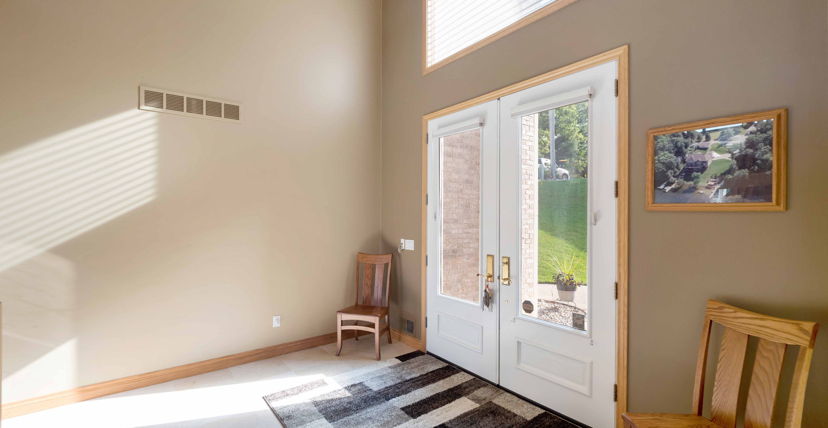 entryway with a high ceiling, french doors, and natural light