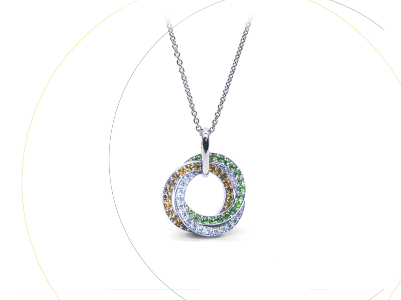 pendentif de forme ronde en or blanc avec trois cerceaux  de pierres; Citrines, émeraudes et diamants.