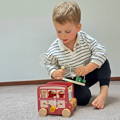 Kid opening a top piece from the Smart Safari Bus toy to take wooden animals out.