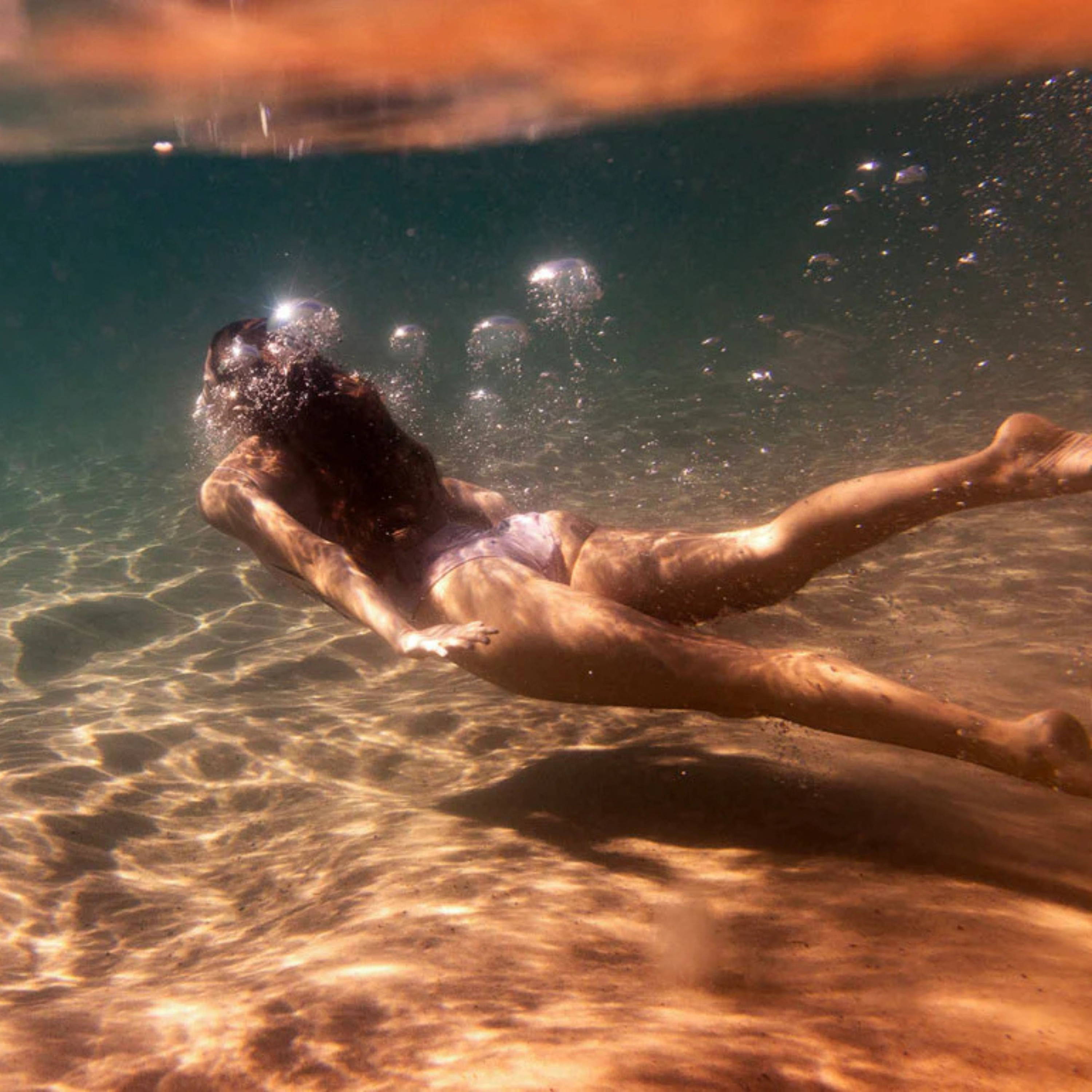 Milos Glow 01 by Francesca Owen - A photography print capturing a swimmer underwater.