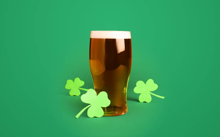 Paper shamrocks around a pint of beer for Confetti's Virtual Irish Beer Tasting with Beer Tasting Set