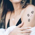 woman with three cat paw tattoo with hearts on arm