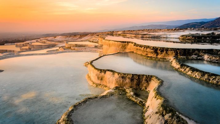 Pamukkale's travertine terraces, shaped by thermal waters, create a unique landscape
